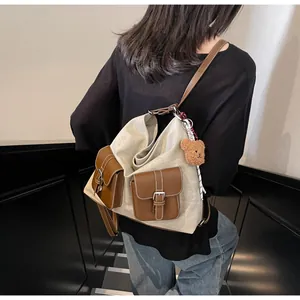 Detail of vintage canvas tote with leather pockets and cute plush bear charm decoration