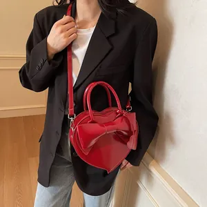 Elegante borsa a mano a forma di cuore rossa in pelle con fiocco e tracolla regolabile