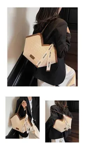 Detail of a large woven tote bag with geometric V-cut and stylish branded webbing strap