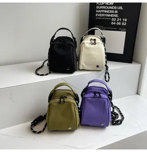 Detail of small nylon shoulder bags in four colors with distinctive braided rope straps