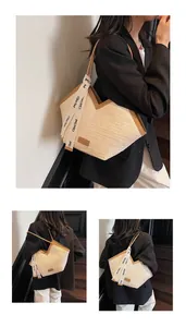 Detail of straw woven tote bag with brown leather trim and stylish logo ribbon straps