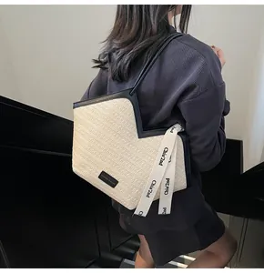 Detail of woven tote bag with V-cut opening, black leather trim and chic branded strap