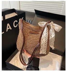 Detail of woven straw tote bag with lace bow inside premium black gift packaging box