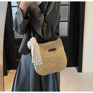 Detailed close-up of handmade woven straw bag with white lace ribbon and brown patch