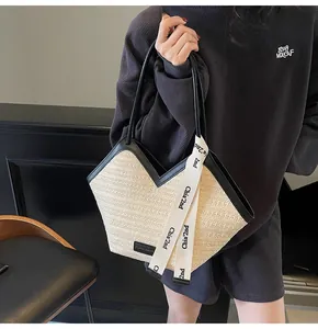 Detail of woven tote bag with black leather handles and printed silk ribbon decor