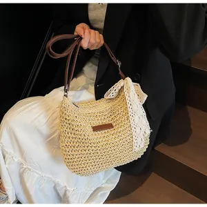 Detail of hand-woven straw bag with a white lace bow and brown leather strap