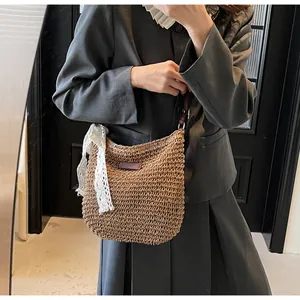 Close-up of woven straw bucket bag with white lace bow and brown leather patch