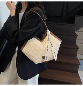 Close-up of woven tote bag featuring dark brown leather trim and white decorative ribbon