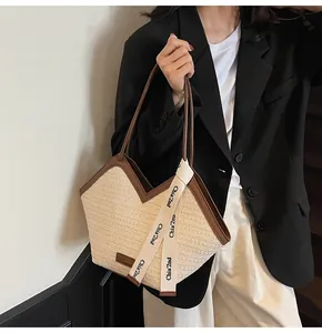 Detail of woven tote bag with brown leather trim and asymmetric V-shaped neckline