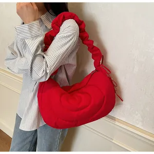 Detailed shot of a red quilted cloud bag showing the pleated strap and soft fabric texture