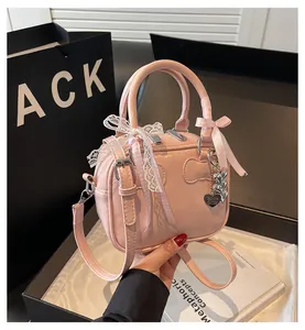 Detailed shot of pink mini Boston bag with ribbon bows and heart-shaped pendant