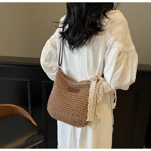 Detailed texture of brown straw woven bag with white lace bow and leather strap