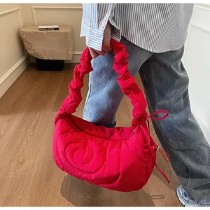 Close-up of bright red quilted bubble bag featuring ruched strap and drawstring details