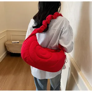 Close-up of red quilted nylon dumpling bag featuring ruffled shoulder strap detail