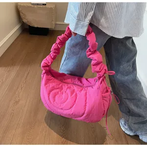 Detail of hot pink quilted dumpling bag with ruffled handle and stylish swirl stitching