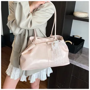 Detail of soft leather tote bag with lace bow and pearl pendant in light pink