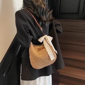 Woven straw bucket crossbody bag with large white lace bow for summer beach vacations