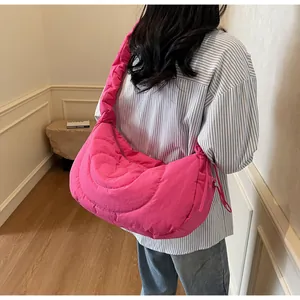 Detail of hot pink quilted crossbody bag featuring heart-shaped stitching pattern