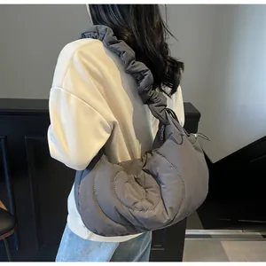 Detail of grey quilted nylon crescent bag featuring a stylish cloud-like pleated strap