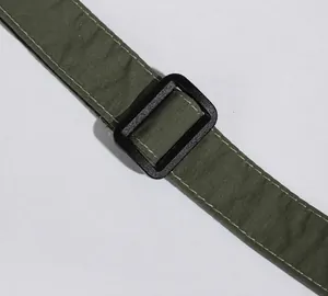 Dettaglio tracolla regolabile in nylon verde militare con fibbia in plastica nera resistente
