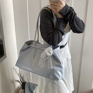 Light blue faux leather tote bag with lace bow and pearl pendant on a model