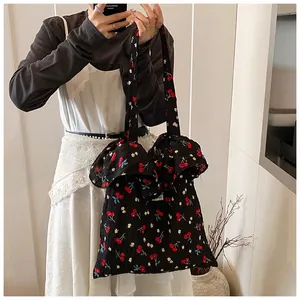 Detail of cherry floral print tote bag with elegant ruffled edges and crepe texture