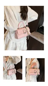 Detail view of pink PU leather handbag featuring silver U-buckle and woven rope charm