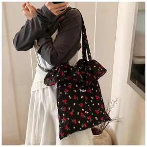 Detail of black cherry floral tote bag featuring elegant chiffon ruffle trim edge