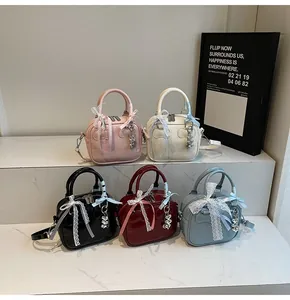 Detailed view of fashionable bowling bags in multiple colors with bear charms and ribbons
