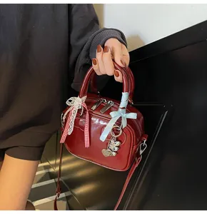 Detail of red patent leather bowling bag with red plaid and light blue bow charms