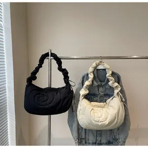 Close-up of quilted puffy shoulder bags in black and beige with scrunchie straps