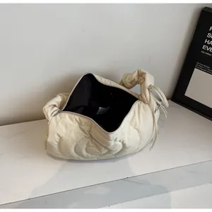 Top view of cream quilted puffer bag showing spacious interior and black lining detail