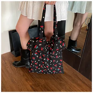 Close-up of black mesh tote bag featuring cherry print and delicate chiffon ruffles