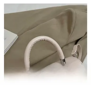 Detail of round top handle with silver hardware and chic woven charm on pink handbag
