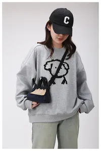 Dettaglio mini borsa a tracolla blu navy con patta color crema e logo su outfit casual modello