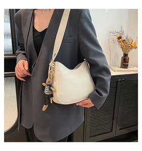 Detail of white lychee pattern hobo bag with cute bunny pendant and shoulder strap