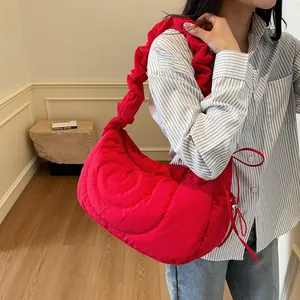 Bright red heart quilted dumpling bag with scrunchie strap shown on model lifestyle