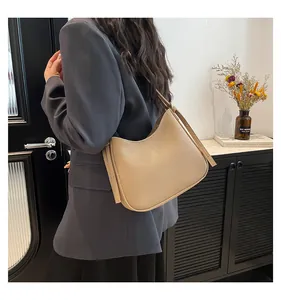 Beige hobo shoulder bag with pebble grain leather texture shown in a lifestyle setting