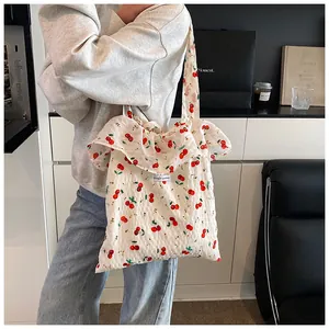 Detailed view of mesh cherry print tote bag with ruffled edges and Magic Pocket tag