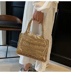 Detalle de bolso tejido a mano en hilo dorado con forro de cordón crema para vacaciones