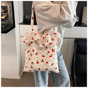 Close-up of mesh tote bag featuring cherry floral print and elegant ruffle trim details