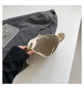 Top view detail of cream bucket bag showing inner zipper pocket and lychee grain leather