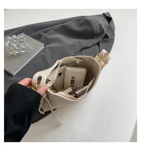 Internal view of beige leather bucket bag showing spacious storage for phone and cosmetics