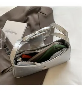Top view of silver metallic bag interior with bow detail showing phone and lipstick space