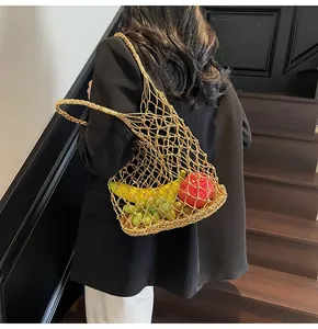 Detalle de bolso de malla metálica dorada con textura calada y correa de punto fino