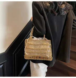 Detalle de bolso de malla tejida dorada con una bolsa interior blanca con cordón ajustable