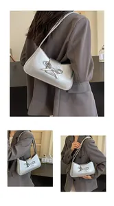 Detail shots of silver metallic underarm bag with vintage pleats and bow decoration
