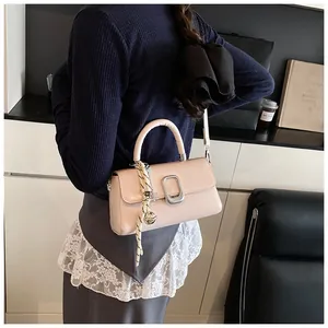 Close-up of pink crossbody bag with silver buckle and stylish striped scarf detail