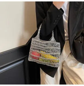 Detalle de un bolso de ganchillo plateado metalizado con textura de malla entrelazada