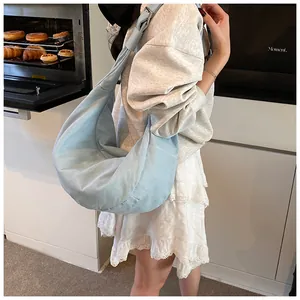 Détail du sac bandoulière demi-lune bleu clair avec bandoulière nouée et tissu doux